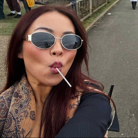 Woman taking a selfie on a sidewalk at a festival